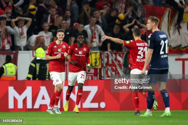 Anton Stach of 1. FSV Mainz 05 celebrates with teammates Danny da Costa and Dominik Kohr after scoring their team's third goal during the Bundesliga...