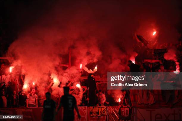 Fans of 1. FC Koeln light flares in the stands during the Bundesliga match between 1. FSV Mainz 05 and 1. FC Köln at MEWA Arena on October 21, 2022...
