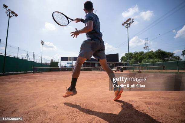 giovane uomo giocare a tennis - tennis foto e immagini stock