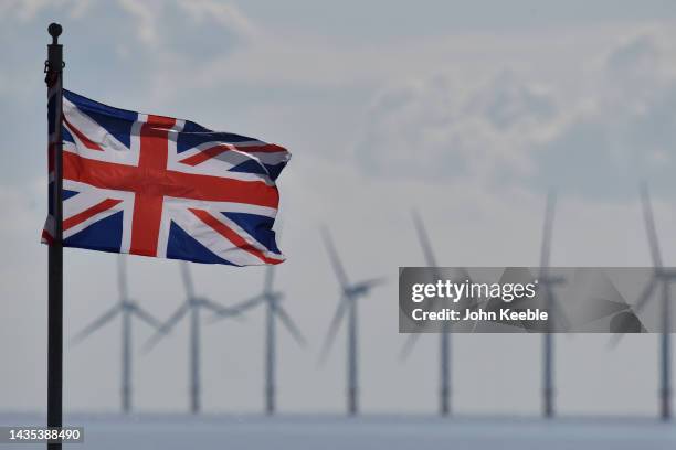 Gunfleet Sands offshore wind farm turbines can be seen as a Union Jack flag flies on September 29, 2022 in Clacton-On-Sea, England. At the recent...