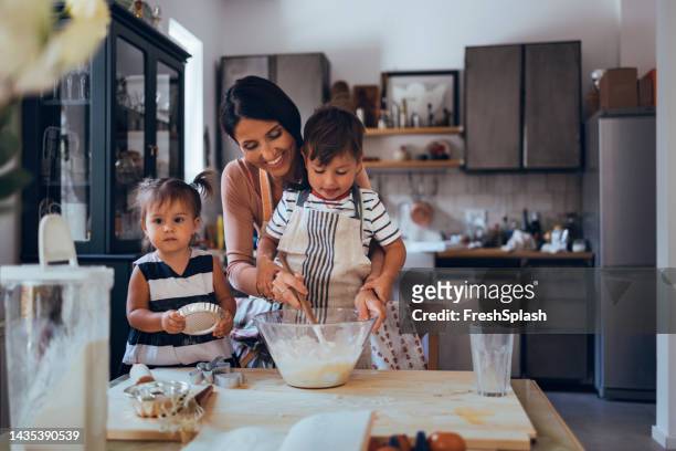 family making a cake together in the kitchen - making cake stockfoto's en -beelden