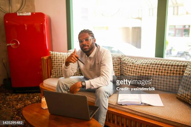 estudiante negro que estudia con computadora en un café haciendo una marca de verificación con la mano - eskisehir fotografías e imágenes de stock