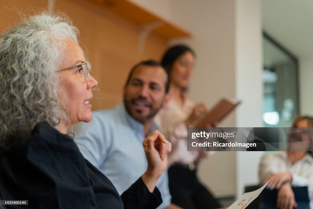 Grupo de empresarios latinos se reúnen en la sala de juntas tomando decisiones sobre la empresa para la que trabajan