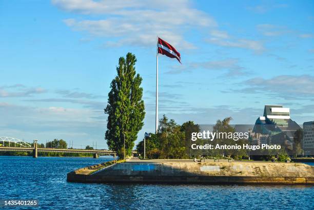 latvian flag hanging from a flagpole and fluttering on the wind. - riga latvia stock pictures, royalty-free photos & images