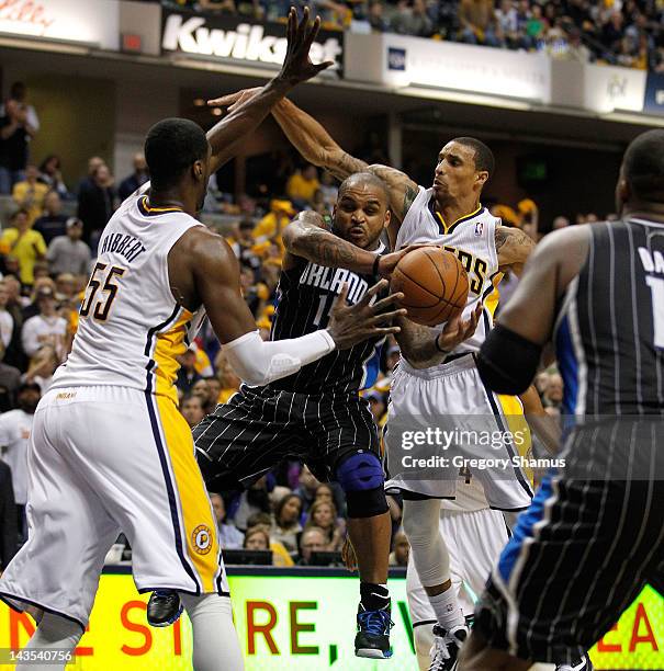 Jameer Nelson of the Orlando Magic passes from between the defense of Roy Hibbert and George Hill of the Indiana Pacers in Game One of the Eastern...
