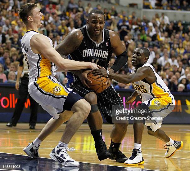 Glen Davis of the Orlando Magic tries to split the defense of Tyler Hansbrough and Darren Collison of the Indiana Pacers in Game One of the Eastern...