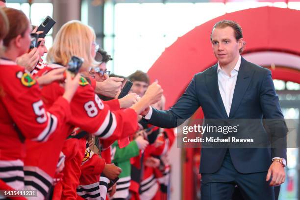 Patrick Kane of the Chicago Blackhawks high fives fans as he arrives to the red carpet prior to the game against the Detroit Red Wings at United...