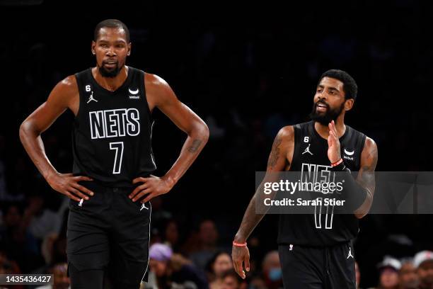 Kevin Durant and Kyrie Irving of the Brooklyn Nets look on during the first half against the Toronto Raptors at Barclays Center on October 21, 2022...