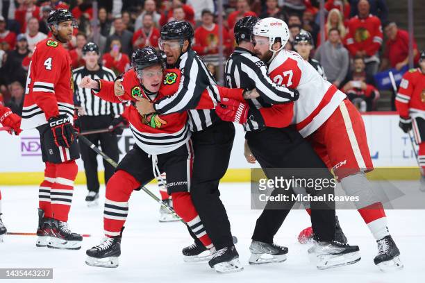 Michael Rasmussen of the Detroit Red Wings and Max Domi of the Chicago Blackhawks fight during the first period at United Center on October 21, 2022...