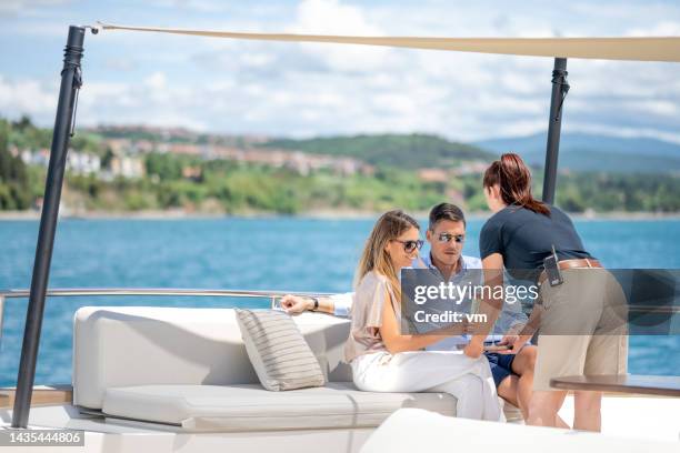 cruise crew servicing clients on yacht - yacht club stock pictures, royalty-free photos & images