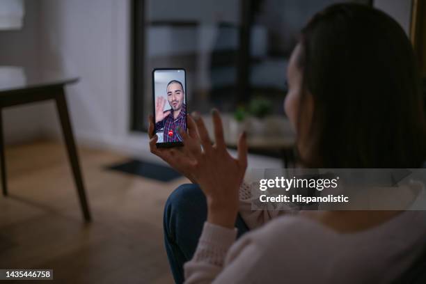 femme à la maison parlant à son petit ami lors d’un appel vidéo - relation à distance photos et images de collection