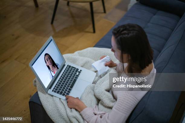 sick woman at home talking to her doctor on a video call - telehealth visit stock pictures, royalty-free photos & images