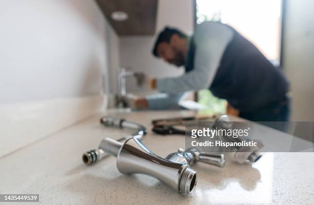 fontanero arreglando una fuga en el fregadero de la cocina de una casa - herramienta fotografías e imágenes de stock