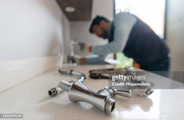plumber fixing a leak in the kitchen sink of a house - tools stock pictures, royalty-free photos & images