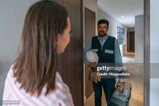 woman at home opening the door to a repairman - man opening door woman bildbanksfoton och bilder