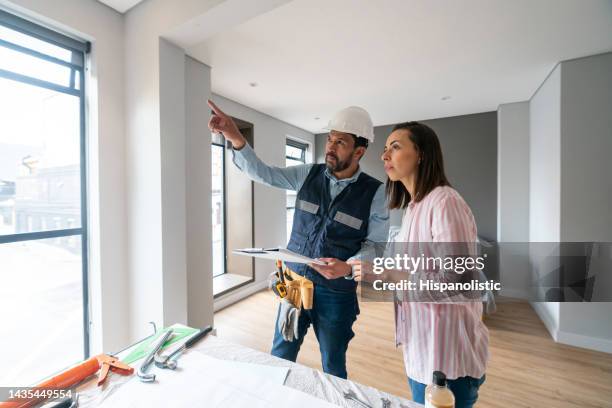 mujer remodelando su casa y hablando con el arquitecto - contratista de obras fotografías e imágenes de stock
