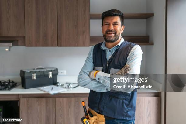 fontanero feliz trabajando en una casa y sonriendo - contratista de obras fotografías e imágenes de stock