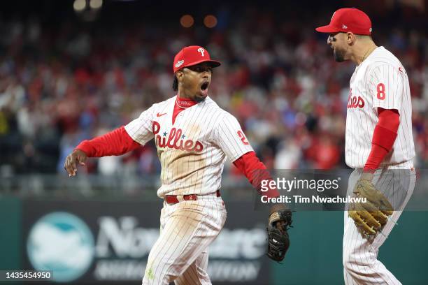 Jean Segura of the Philadelphia Phillies celebrates with Nick Castellanos after making a diving stop and throwing out Ha-Seong Kim of the San Diego...
