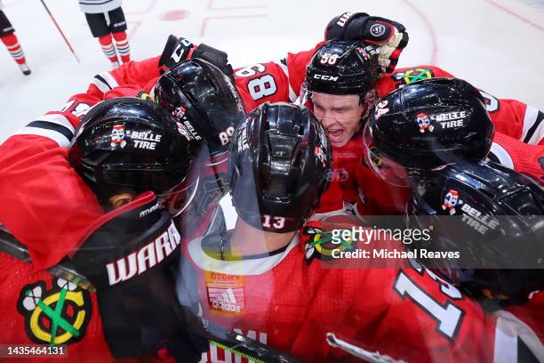 Max Domi of the Chicago Blackhawks celebrates with teammates after scoring a game-winning goal in overtime against the Detroit Red Wings at United...