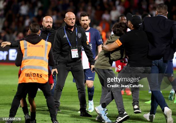 Lionel Messi of PSG is protected by security from fans invading the pitch following the Ligue 1 match between AC Ajaccio and Paris Saint-Germain at...