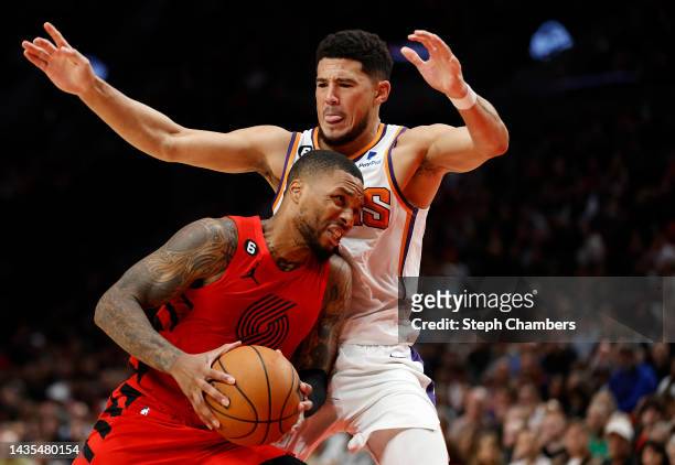 Damian Lillard of the Portland Trail Blazers drives to the hoop against Devin Booker of the Phoenix Suns during the fourth quarter at Moda Center on...