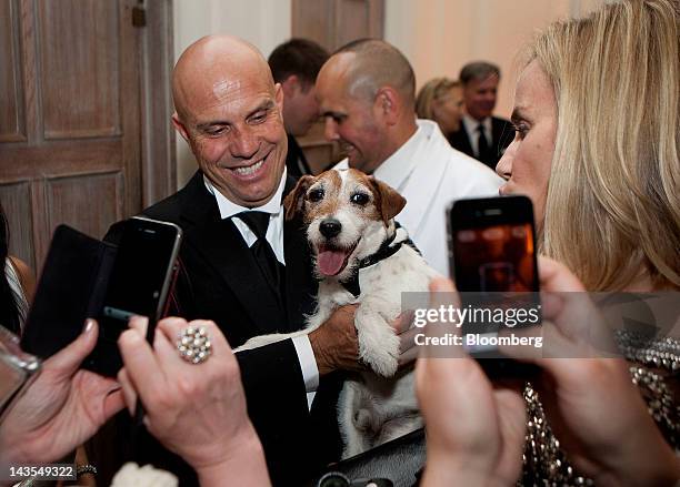 Attendees take photos of Uggie, the dog from the movie "The Artist," at the Bloomberg Vanity Fair White House Correspondents' Association dinner...