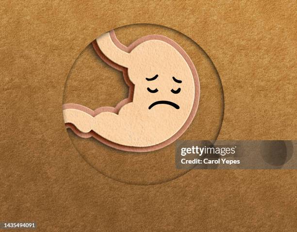 conceptual image of stomach made of felt with sad face. stomach pain - gastric ulcer stock-fotos und bilder