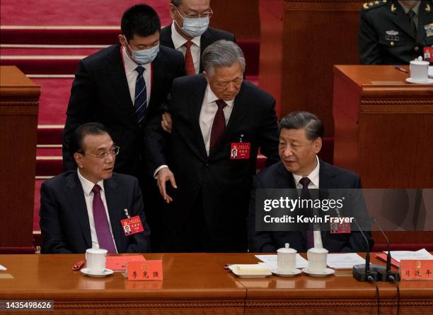 Chinese President Xi Jinping and Premier Li Keqiang, left, look on as former President Hu Jintao, centre, speaks to Xi as he is helped to leave early...