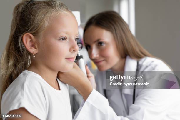 smiling girl having ear exam with otoscope - doctor listener imagens e fotografias de stock