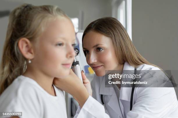 smiling girl having ear exam with otoscope - ear drum stock pictures, royalty-free photos & images