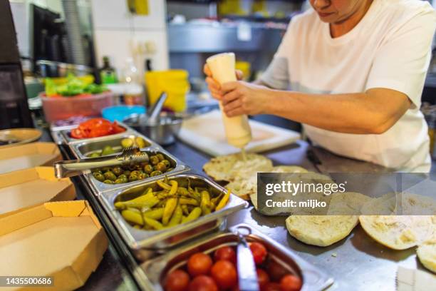 menschen, die in der küche im fast-food-restaurant arbeiten und essen für die lieferung zubereiten - mayonnaise stock-fotos und bilder
