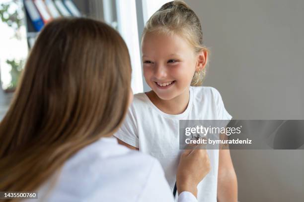 female doctor with stethoscope listen to her heartbeat - phonendoscope stock pictures, royalty-free photos & images
