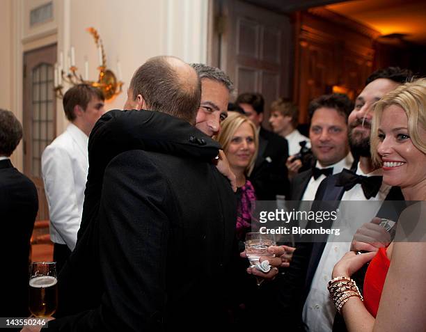 George Clooney, left, hugs Woody Harrelson, as Paul Rudd, second from right, and Elizabeth Banks, right, look on at the Bloomberg Vanity Fair White...