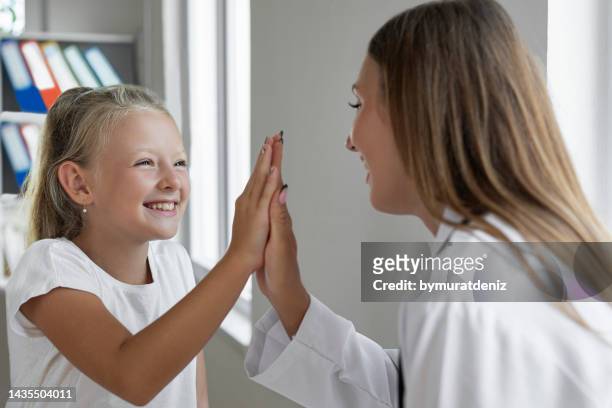 pediatrician giving high five to little patient - doctor general practitioner stock pictures, royalty-free photos & images