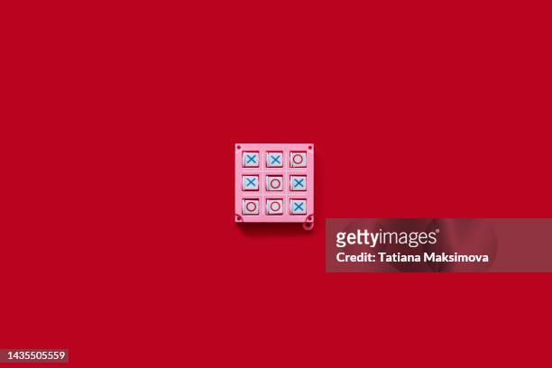 single object tic-tac-toe game on red background, top view. - tic tac toe stock-fotos und bilder