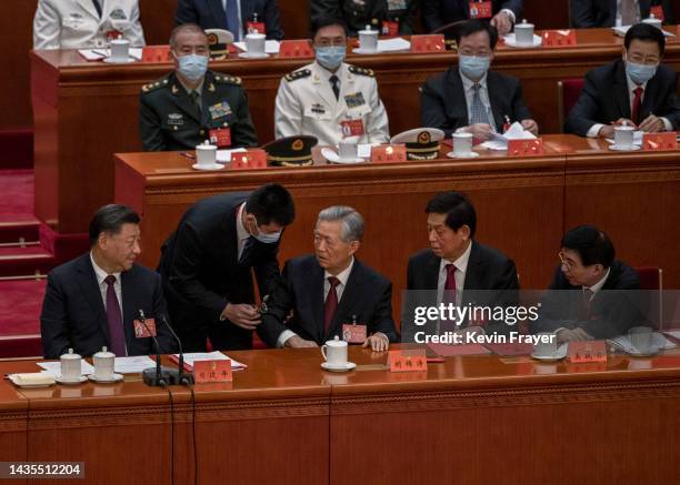 Chinese President Xi Jinping looks on as former President Hu Jintao is helped to leave early from the closing session of the 20th National Congress...