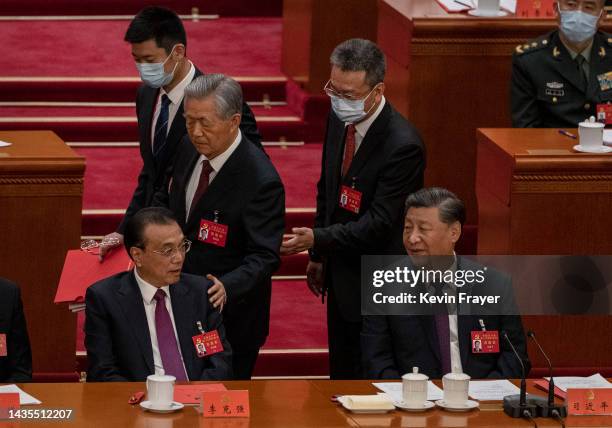 Chinese President Xi Jinping and Premier Li Keqiang look on as former President Hu Jintao is helped to leave early from the closing session of the...