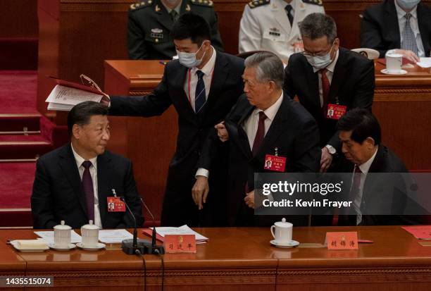 Chinese President Xi Jinping looks on as former President Hu Jintao is helped to leave early from the closing session of the 20th National Congress...