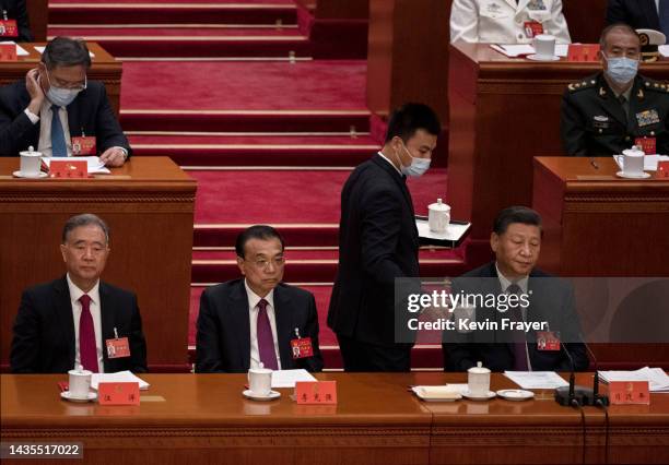 Chinese President Xi Jinping, bottom right, is served a beverage as he sits next to Premier Li Keqiang, second left and Politburo member Wang Yang...