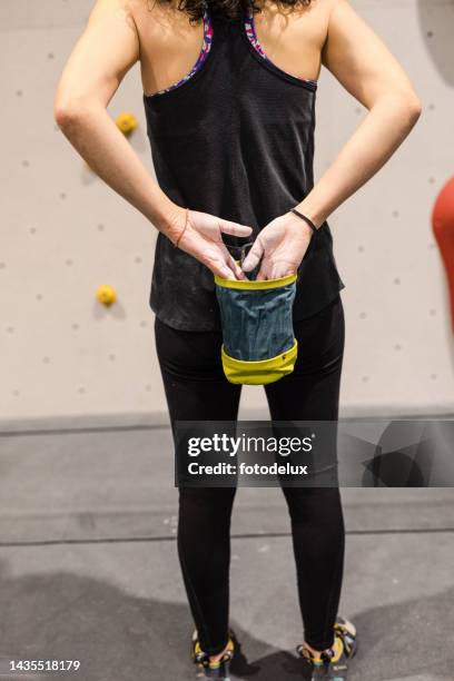 kletterin kreidet vor ihrem aufstieg in einer boulderhalle - magnesium stock-fotos und bilder