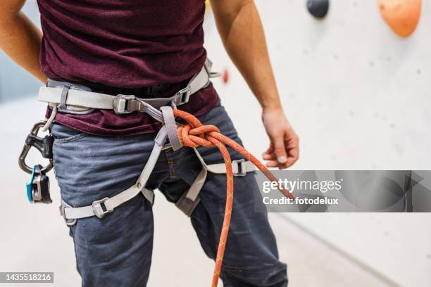 mid section of male climber ready to climb indoor - zekeren stockfoto's en -beelden