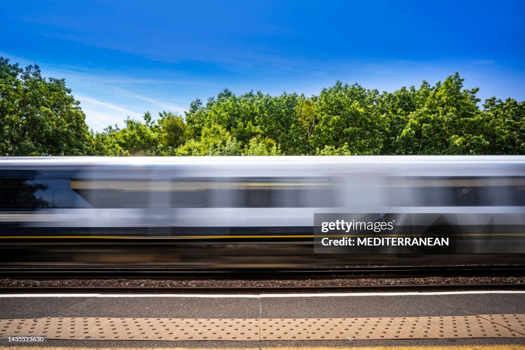 Treno sfocato dal movimento nella zona di Londra nel Regno Unito in una soleggiata giornata estiva in Inghilterra