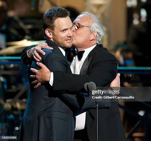 Actors Joel McHale and Chevy Chase embrace onstage at The Comedy Awards 2012 at Hammerstein Ballroom on April 28, 2012 in New York City.