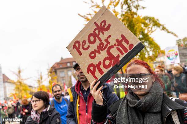 Protester hold a sign that reads "People over profits" as people march to demand a continued shift to renewable energy sources and reduction in...