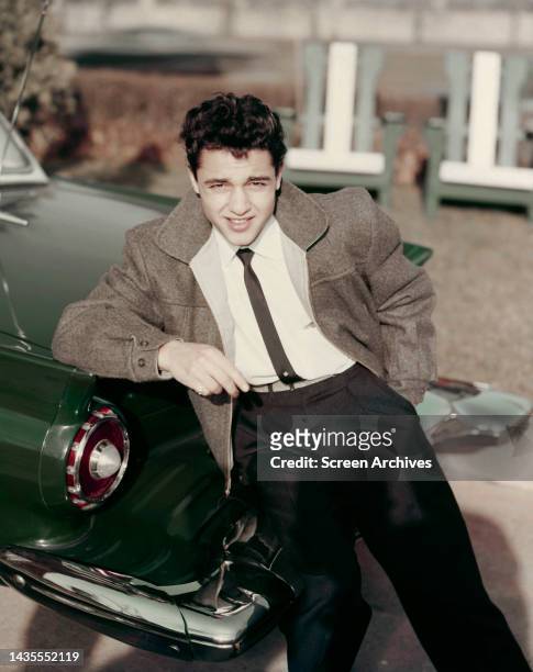 Sal Mineo posing by vintage green American car circa Rebel Without A Cause era 1955.
