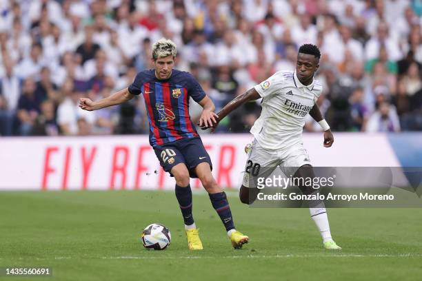 Vinicius Junior of Real Madrid CF competes for the ball with Sergi Roberto of FC Barcelona during the LaLiga Santander match between Real Madrid CF...