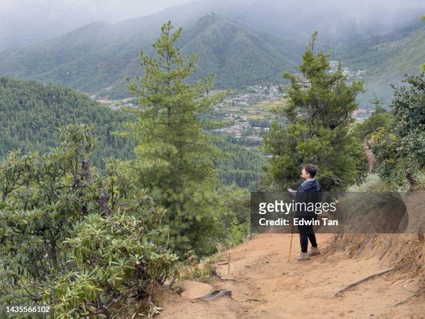 asian chinese female tourist looking at a view hiking at paro taktsang  monastery in bhutan - disparo bildbanksfoton och bilder