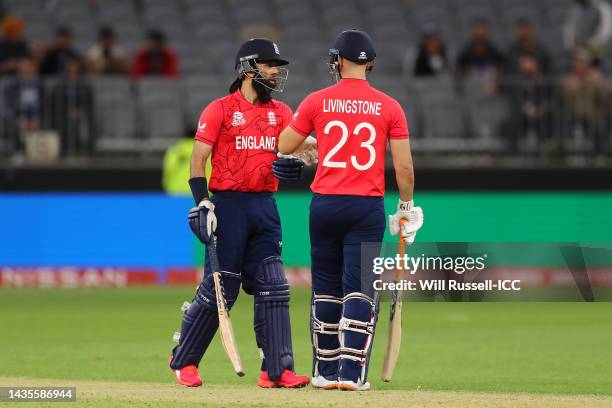 Moeen Ali and Liam Livingstone of England bump gloves as England reaches a century during the ICC Men's T20 World Cup match between England and...