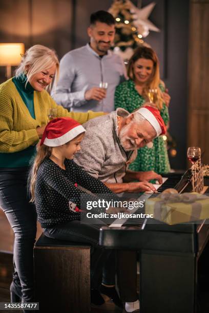 reunión familiar multigeneracional para la celebración de navidad y tocar el piano - villancicos fotografías e imágenes de stock