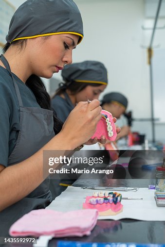 Dentistry student performs her exercises in class while working with ceramic teeth Dentistry student performs her exercises in class while working with ceramic teeth